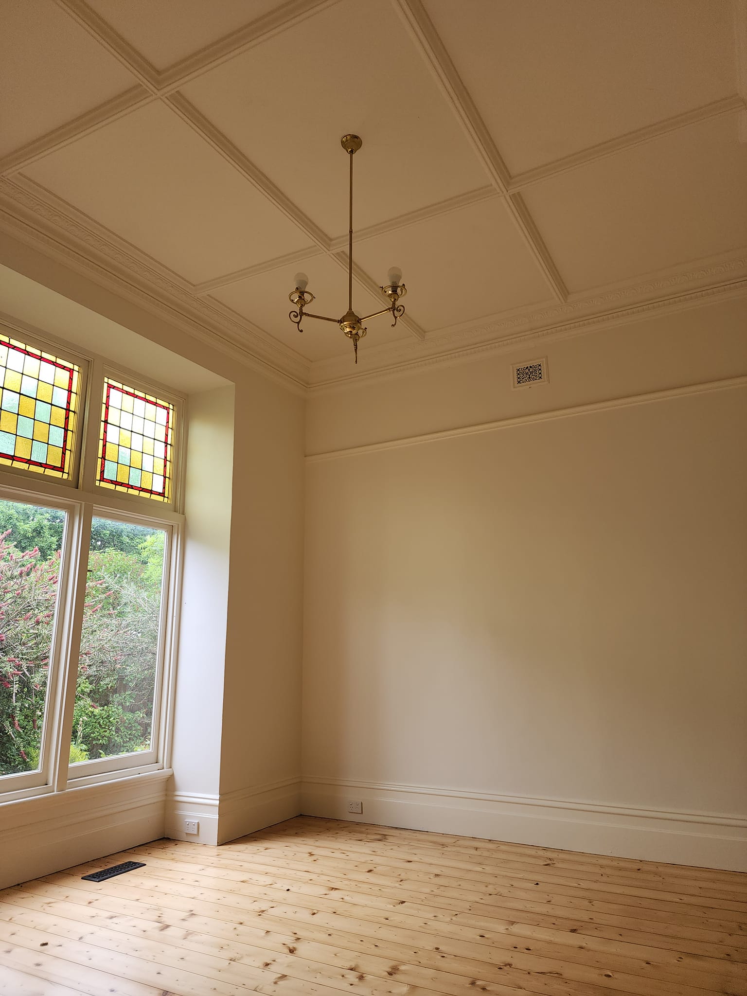 Heritage room with a coffered plaster ceiling, brass chandelier and stained glass windows